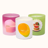 Three candles from Otherland with colorful labels on a white background