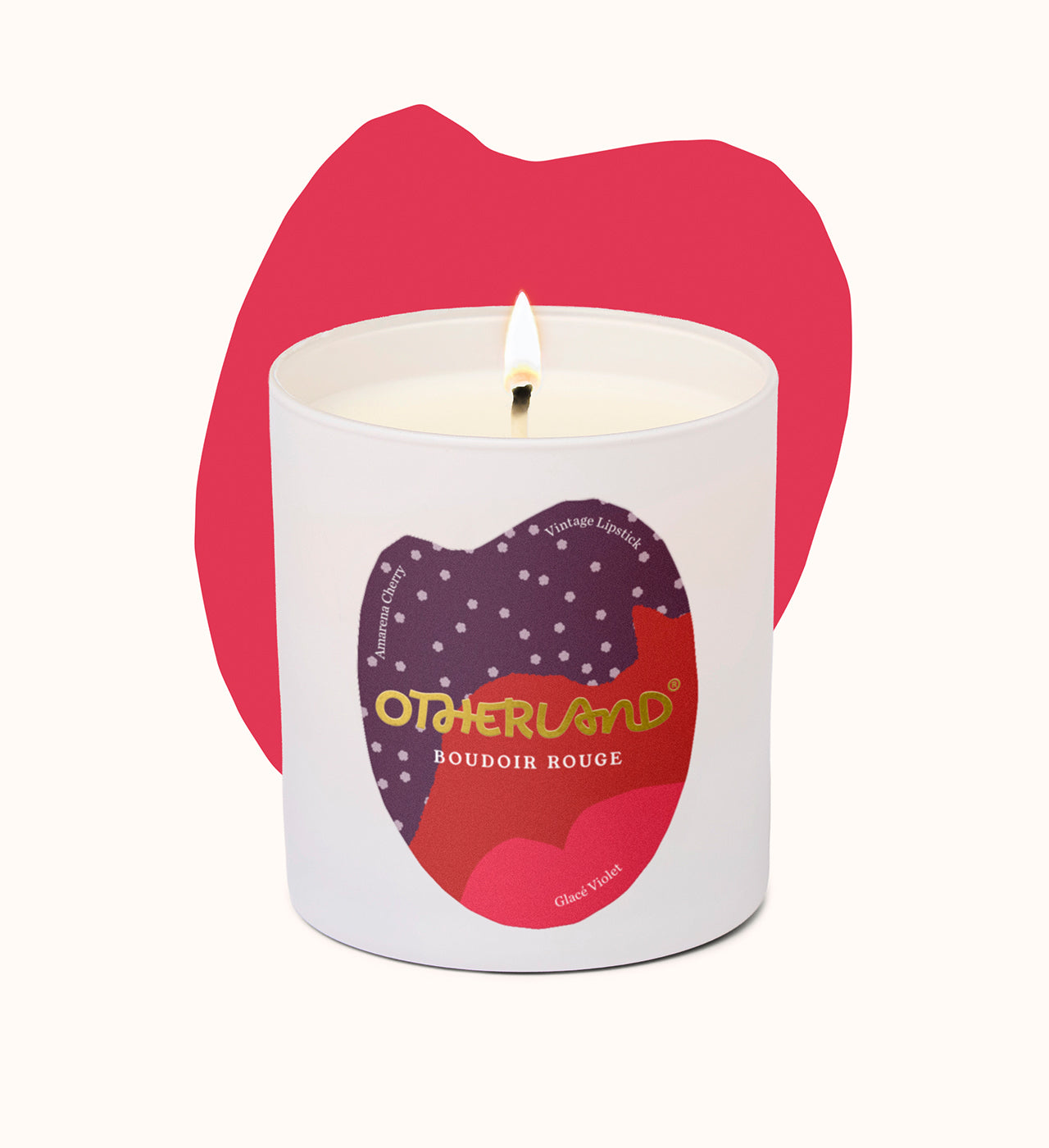 Candle with 'Otherland' branding in front of a pink lip-shaped object