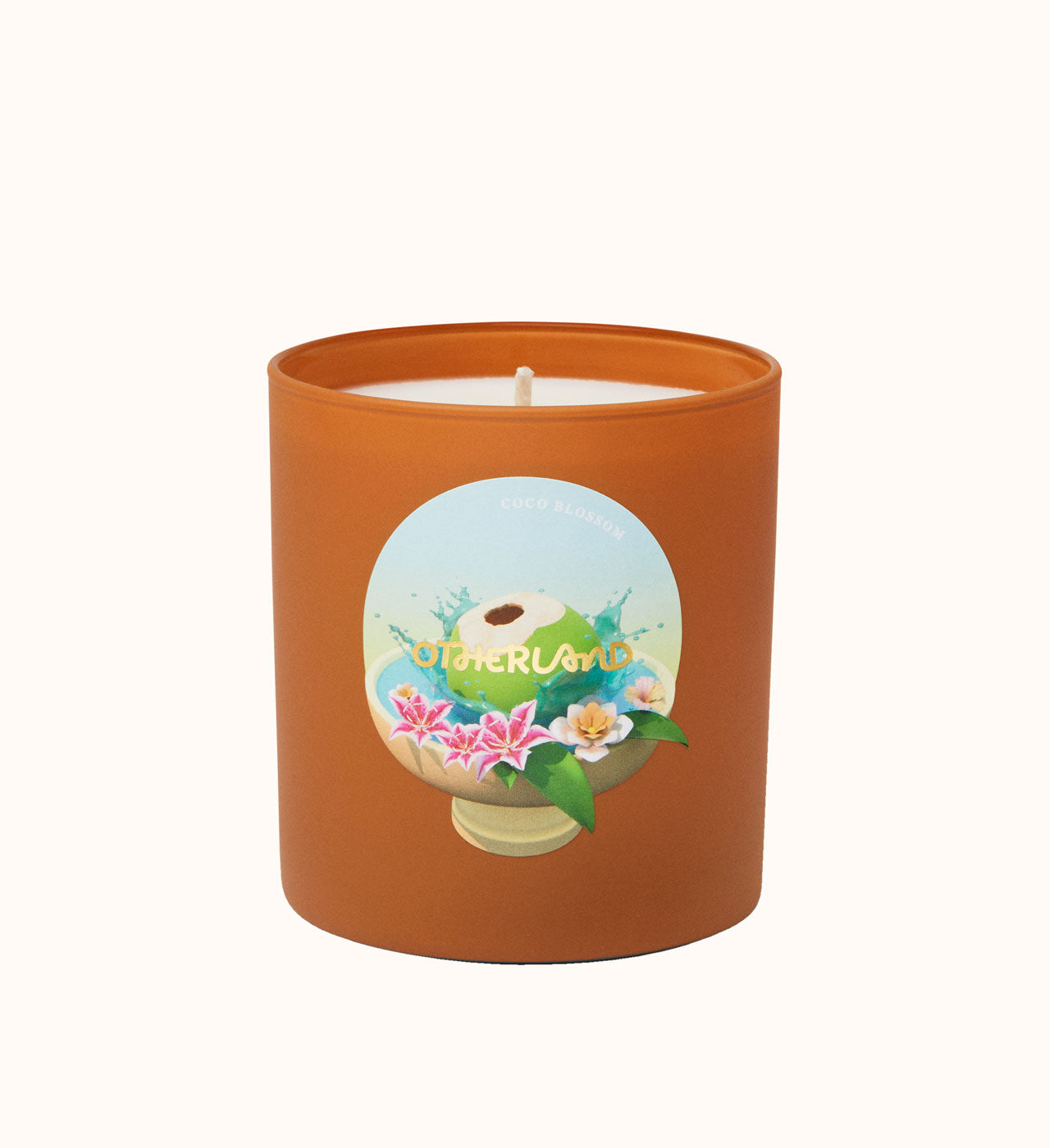 Candle in an orange container with a decorative label on a white background