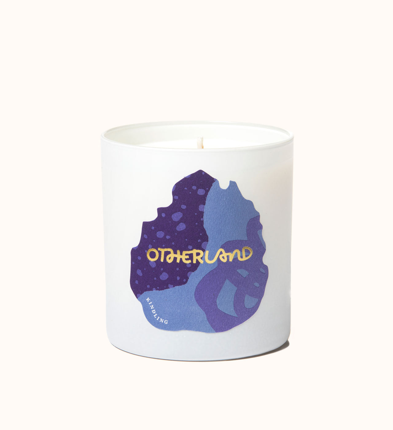 White candle with purple and blue design and 'Otherland' branding on a white background