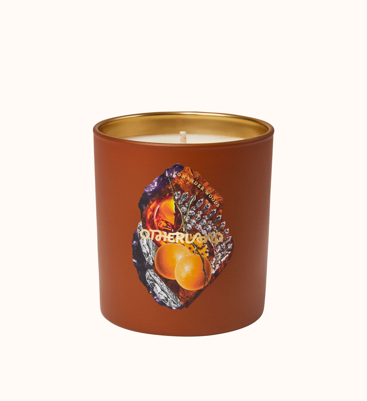 Candle in a brown container with a gold lid on a white background