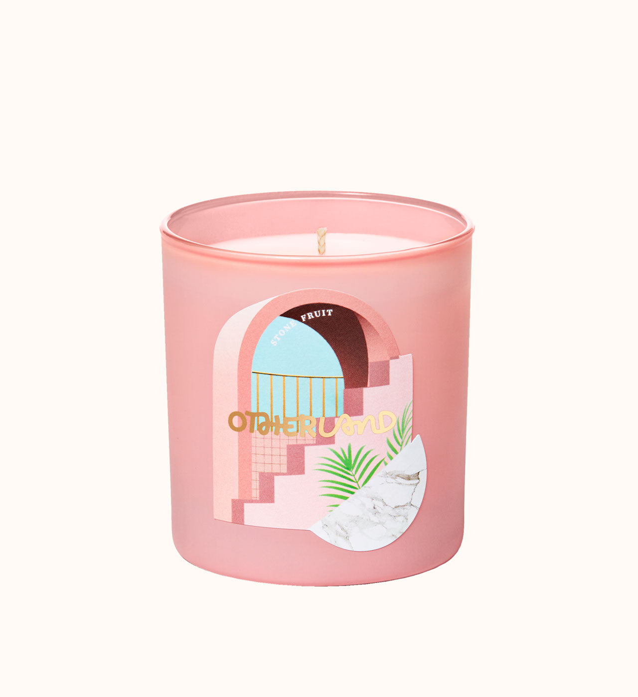 Pink candle with a decorative label on a white background