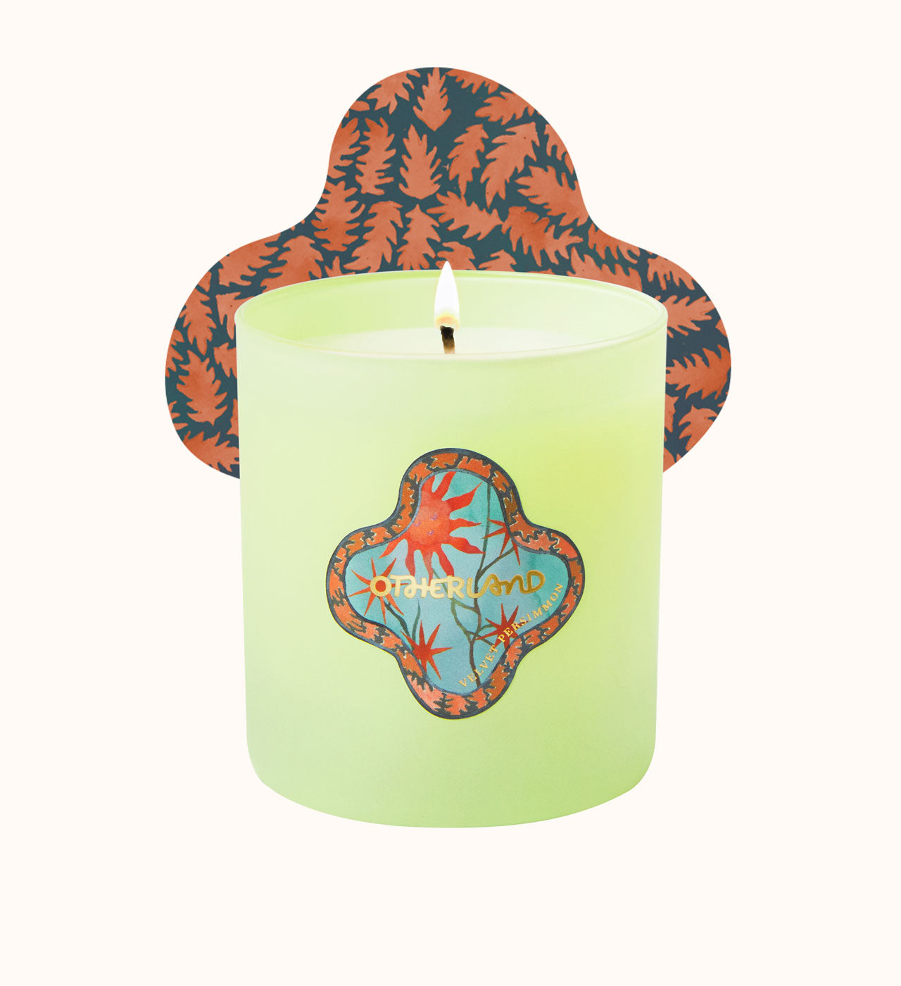 Green candle with a decorative lid featuring abstract designs on a white background