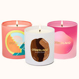 Three scented candles with 'Otherland' branding on a white background