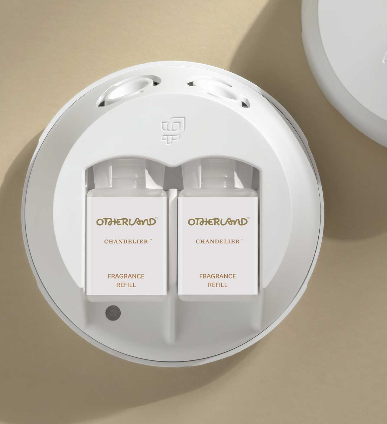 White fragrance refills in a Pura dispenser with 'Otherland' branding on a beige background
